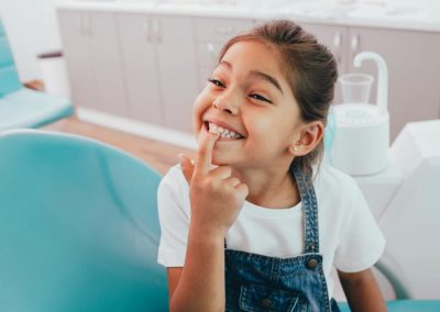 Ein kleines Mädchen zeigt dem Fachzahnarzt Ihre Zähne